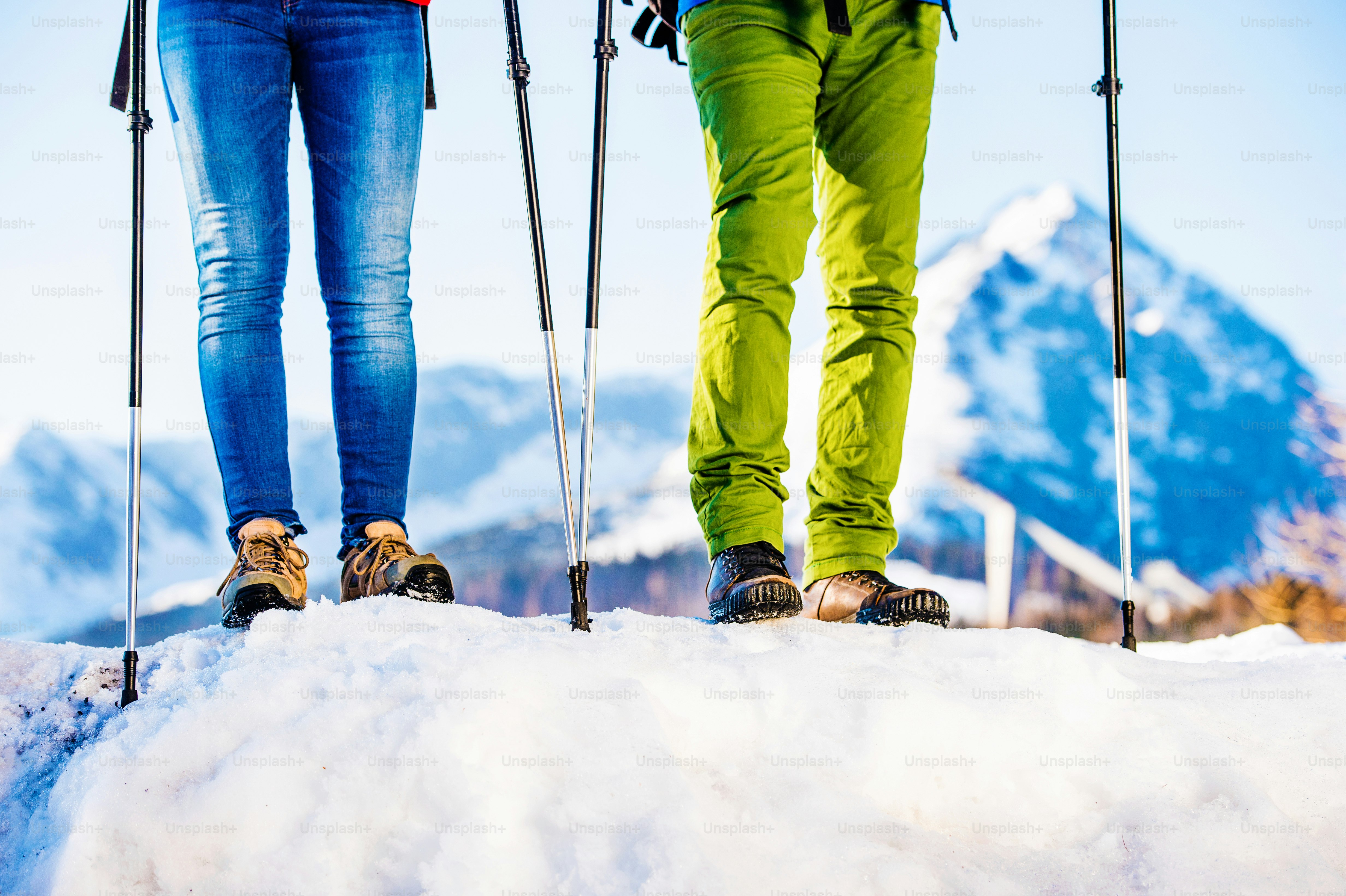 Young couple hiking outside in sunny winter mountains