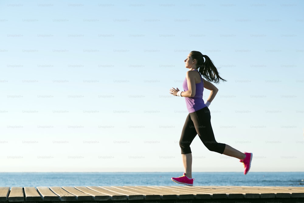 Young woman is running in sunny nature