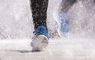 운동 선수 여자는 추운 눈 날씨에 밖에서 겨울 훈련 중에 달리고 있습니다.