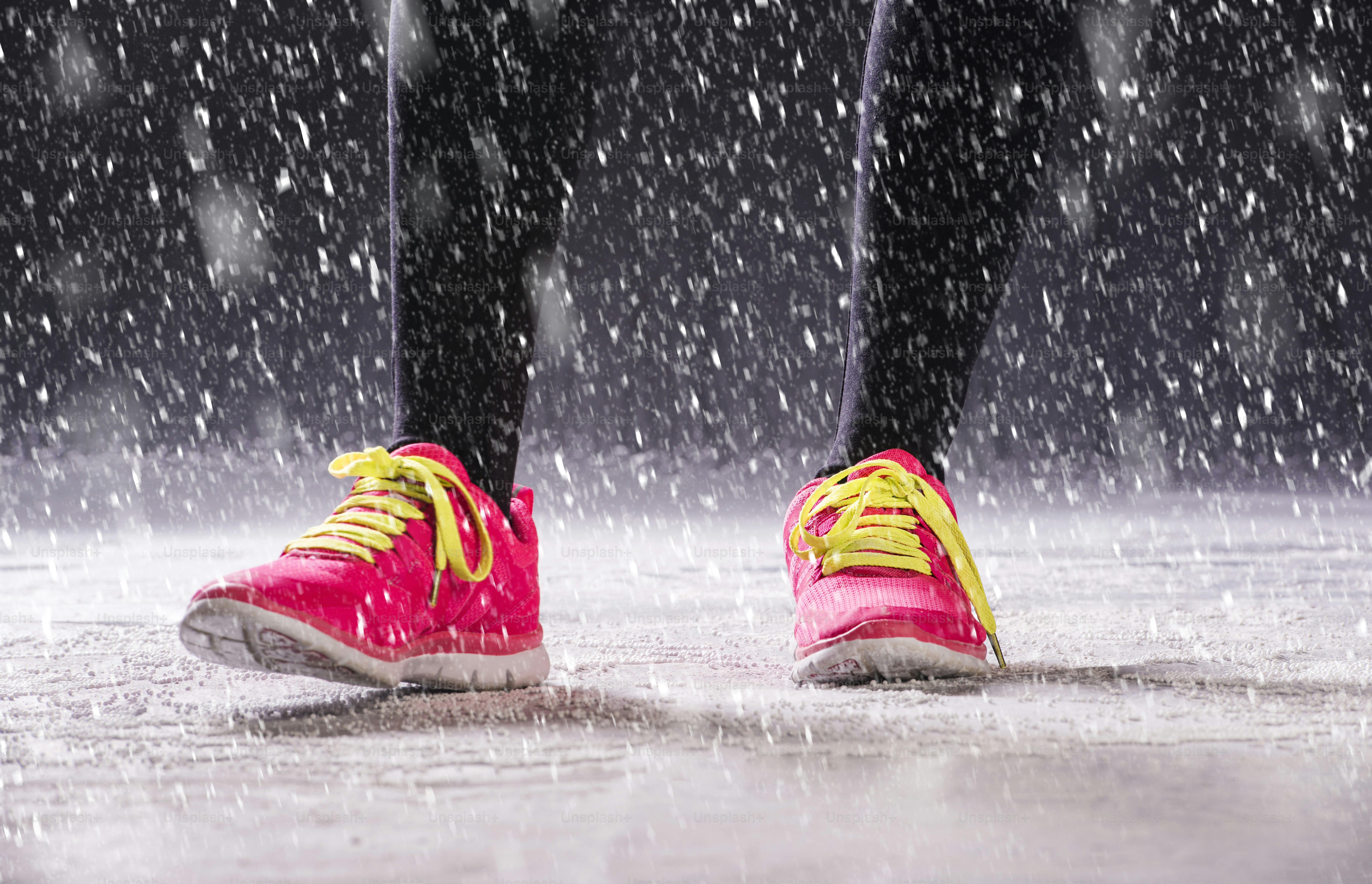La mujer atleta está corriendo durante el entrenamiento de invierno al aire libre en un clima frío de nieve.