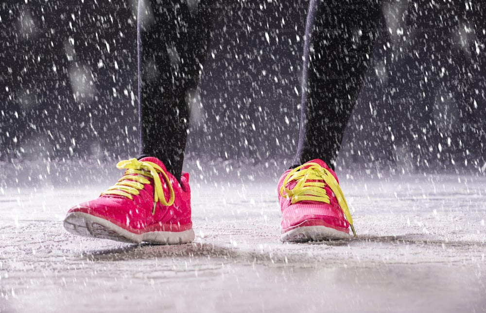 운동 선수 여자는 추운 눈 날씨에 밖에서 겨울 훈련 중에 달리고 있습니다.