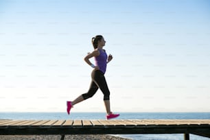 Young woman is running in sunny nature