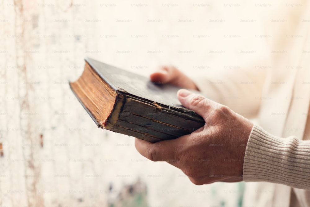 Mulher irreconhecível segurando uma bíblia em suas mãos