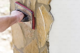 Mason putting decorative natural stones on a wall