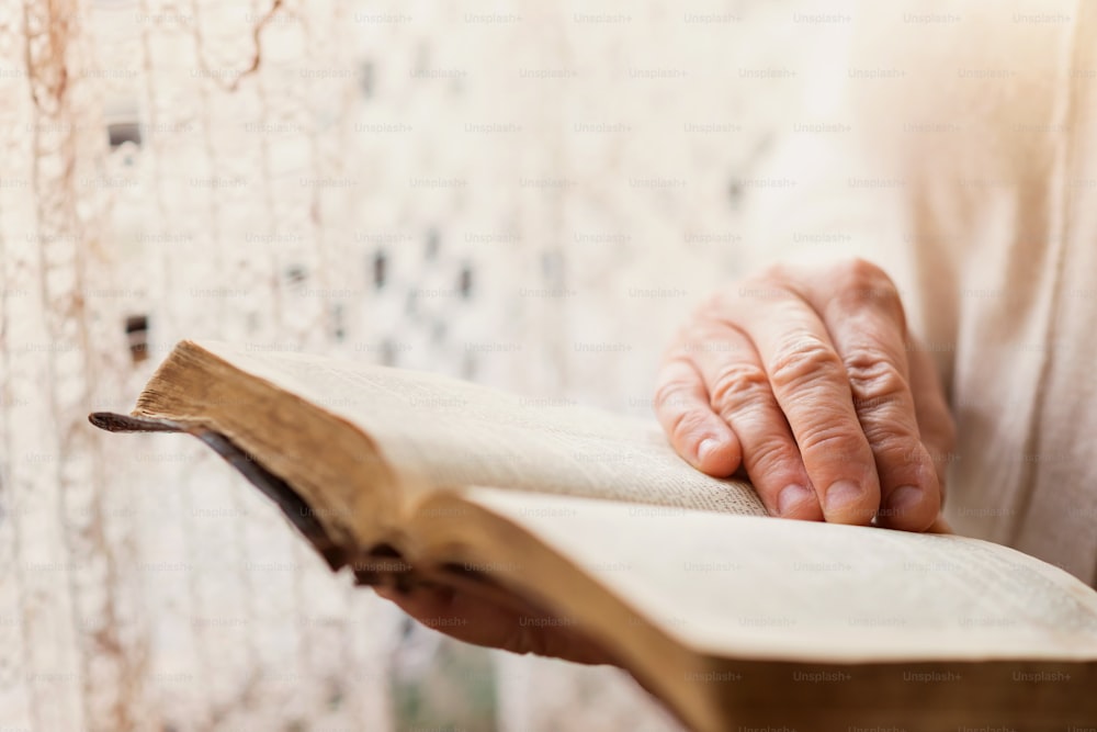 Femme méconnaissable tenant une bible dans ses mains