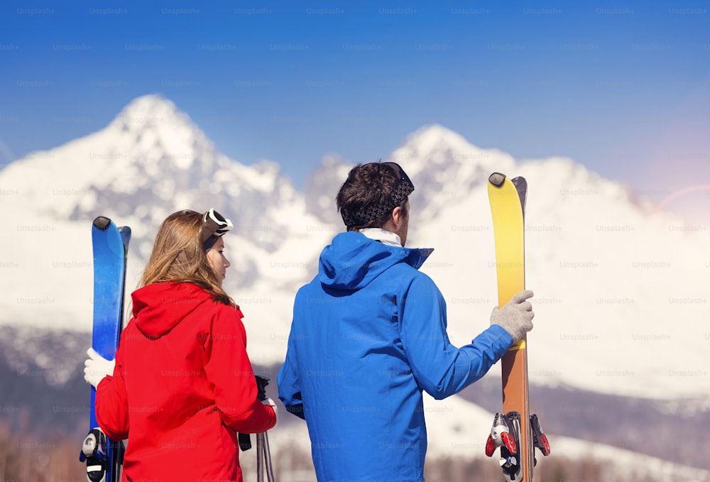햇볕이 잘 드는 ��겨울 산에서 스키를 타는 젊은 부부