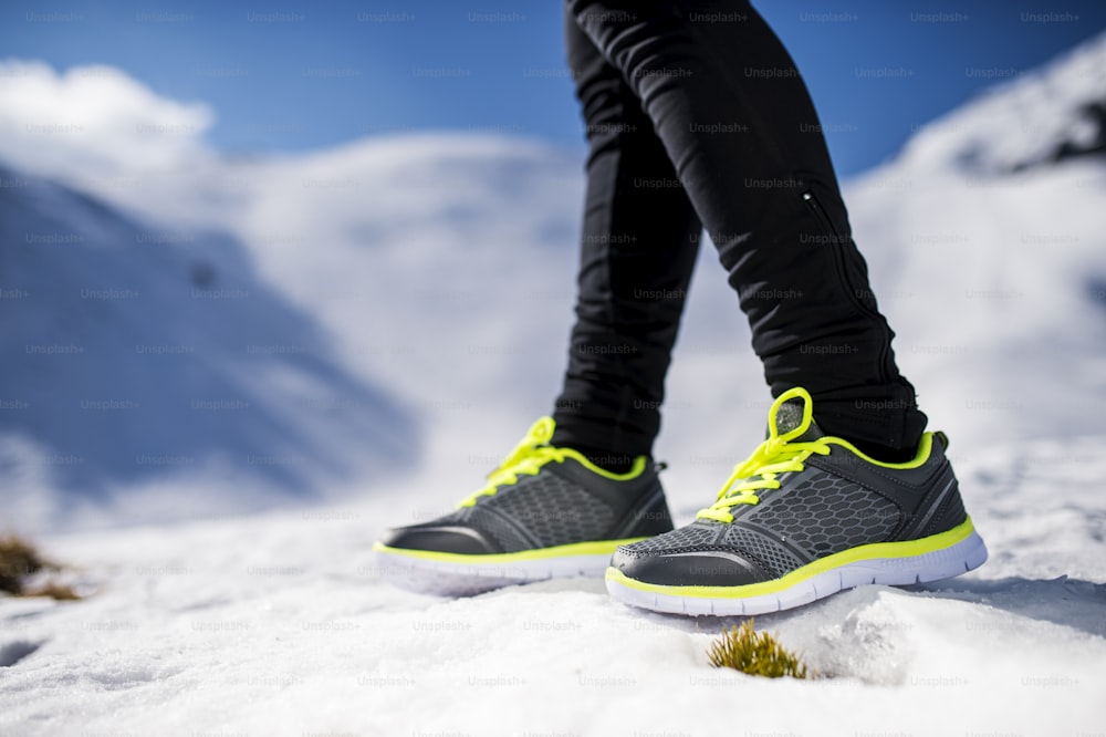 Piernas de un joven corredor al aire libre en la naturaleza invernal