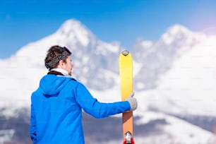 Young couple skiing outside in sunny winter mountains