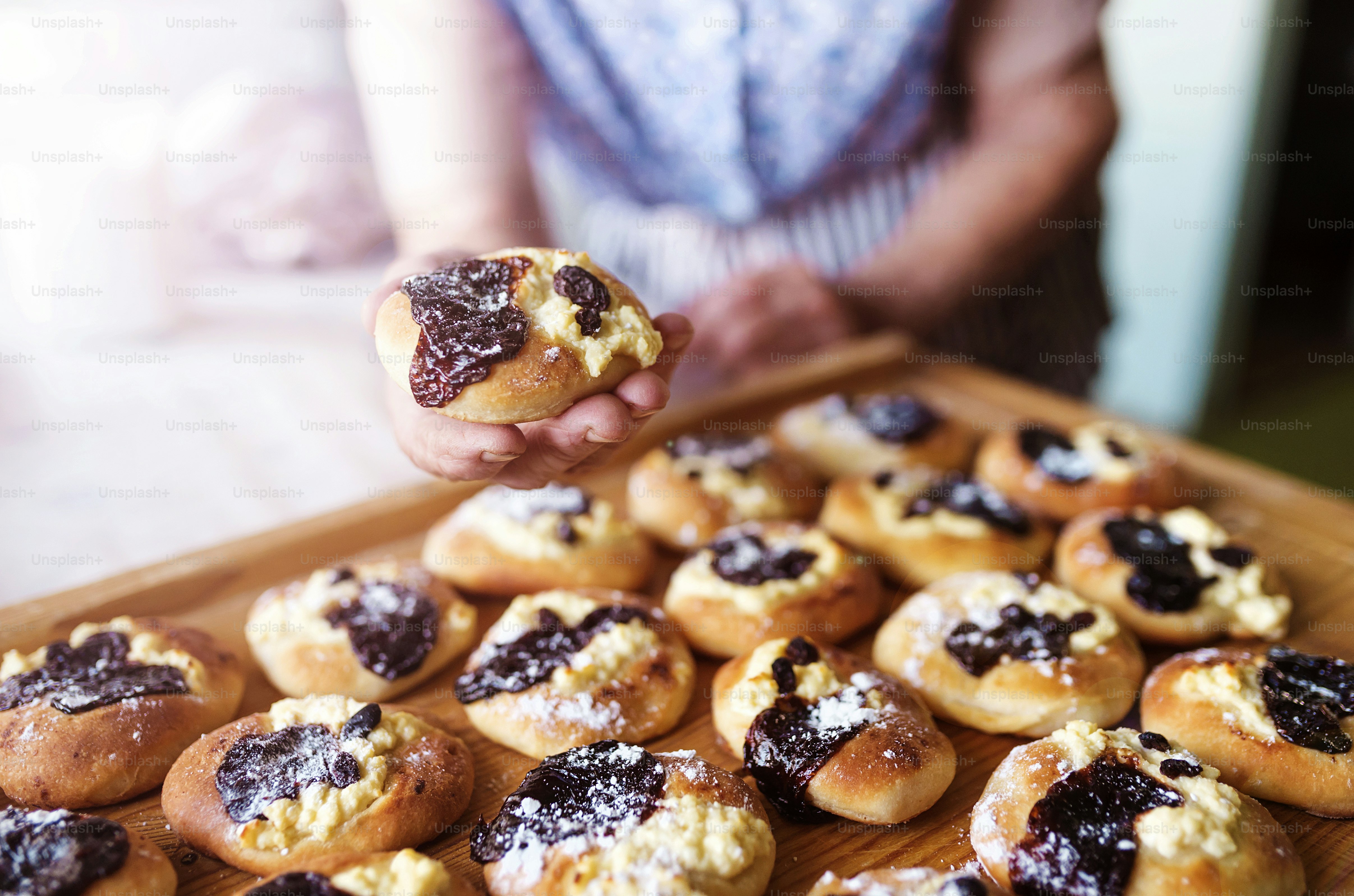 Senior woman holding freshly baked sweet buns.
