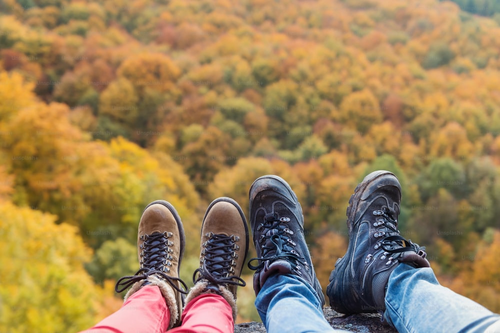 Unkenntliches junges Paar bei einer Wanderung im Herbstwald