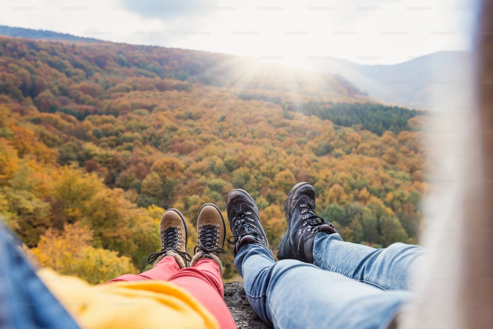 Unkenntliches junges Paar bei einer Wanderung im Herbstwald