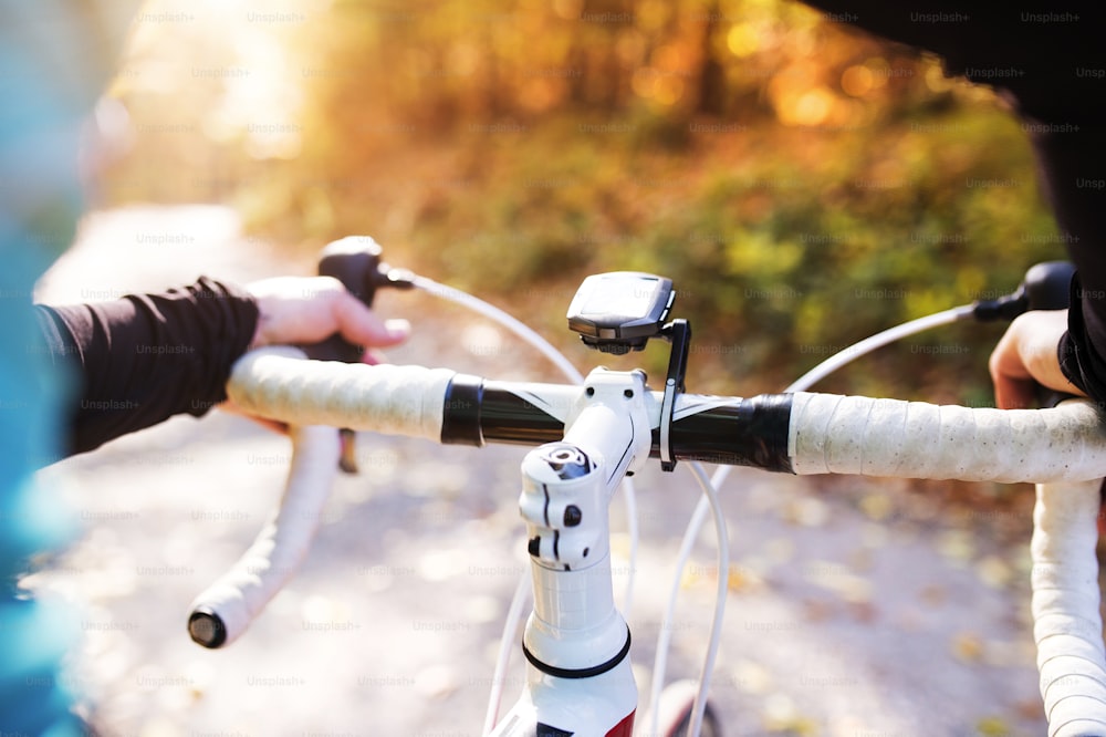 Junger, gutaussehender Sportler mit dem Fahrrad draußen in sonniger Herbstnatur