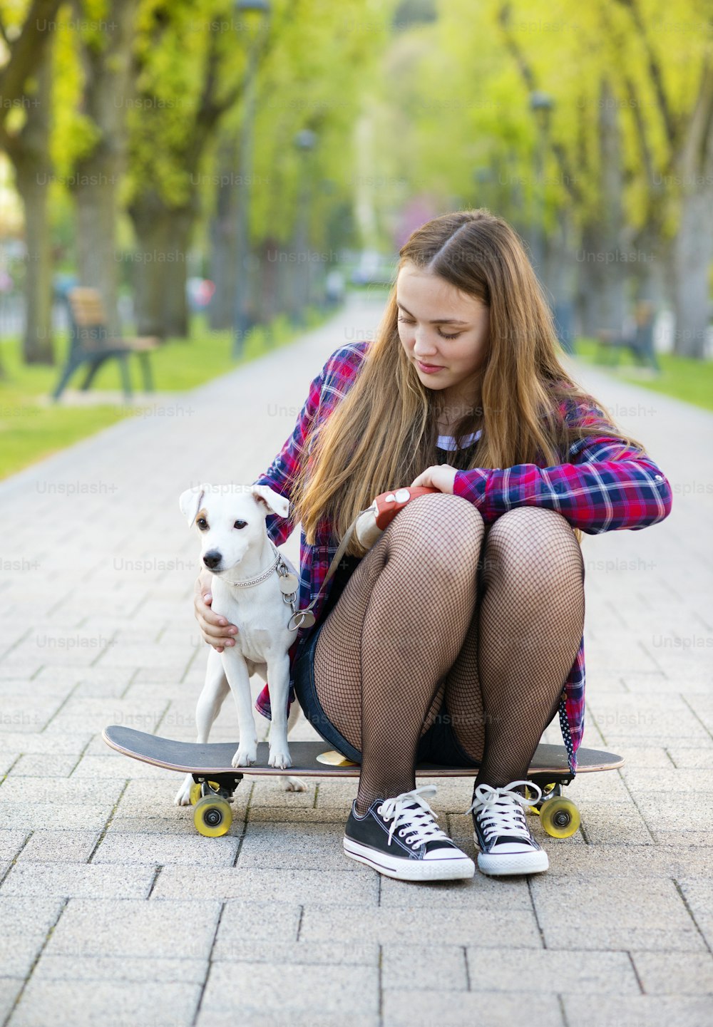 Teenage girl on skateboard with her dog