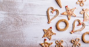 Christmas straw decoration. Studio shot on white wooden background.