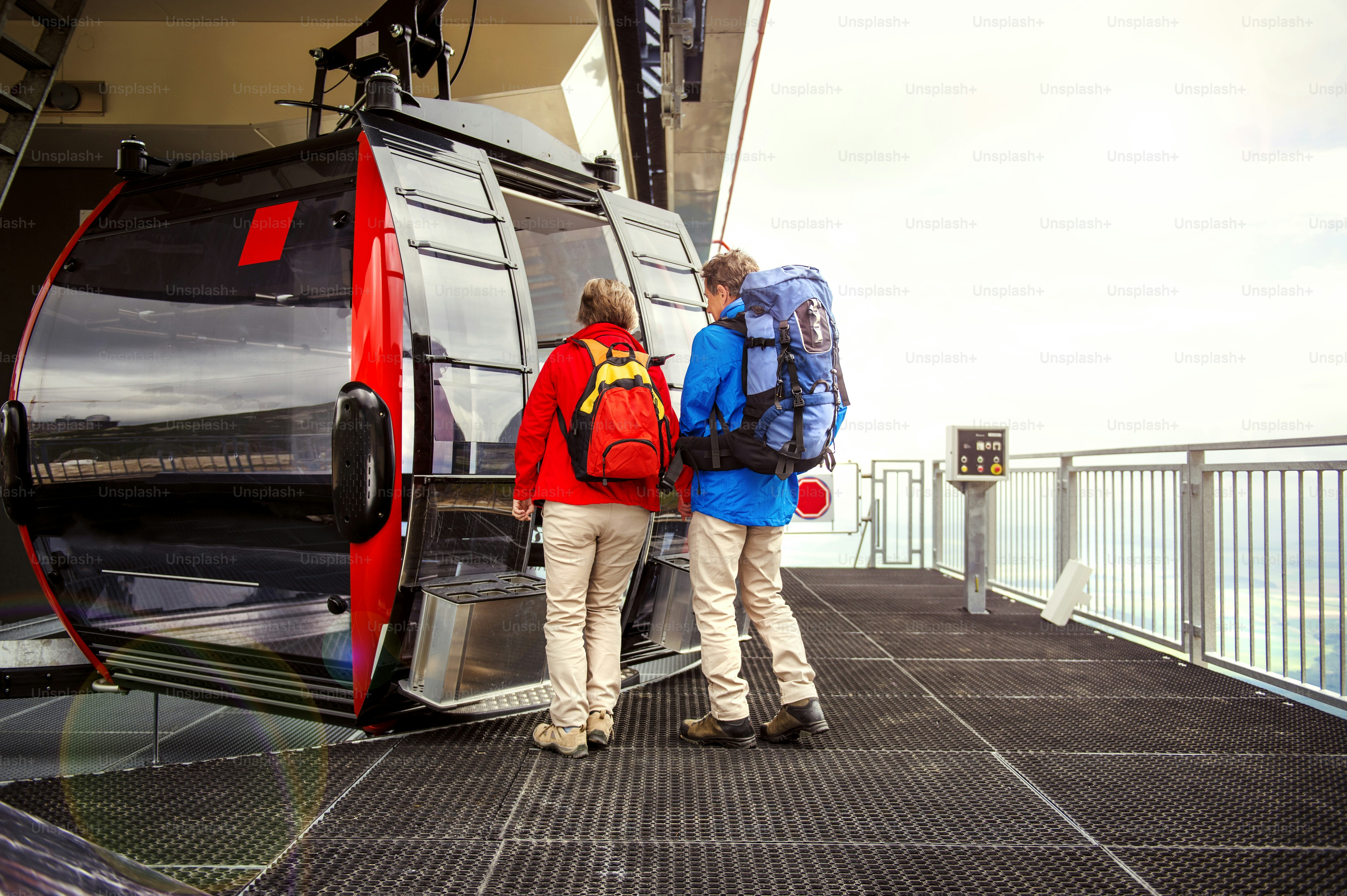 Senior hikers couple is waiting for cableway in cable station