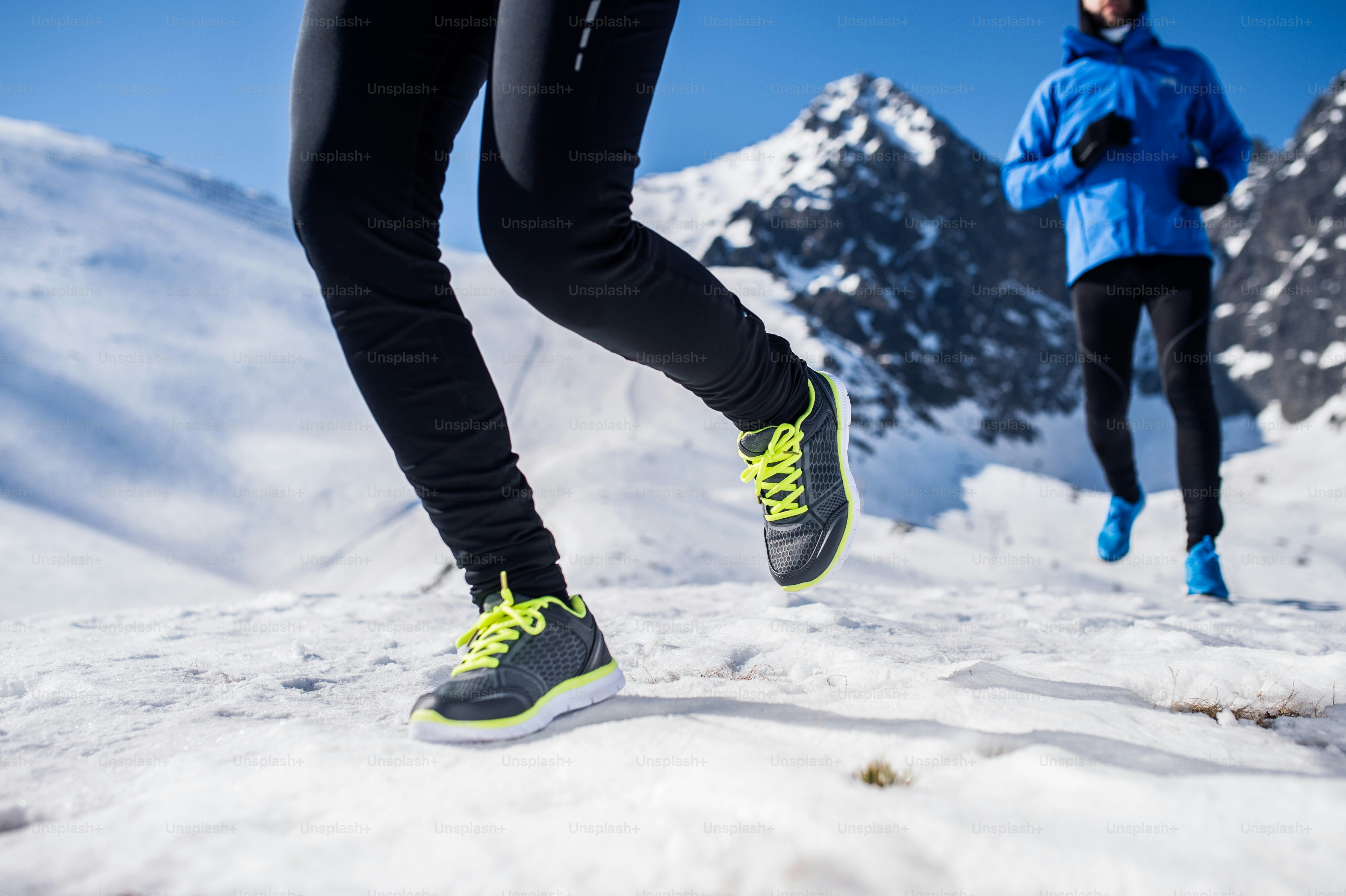 Legs of two runners outside in winter nature
