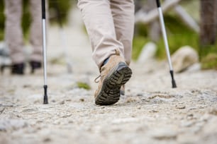 Gros plan sur les jambes d’un couple de personnes âgées faisant de la randonnée dans les belles montagnes