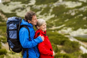 Senior tourist couple hiking at the beautiful mountains