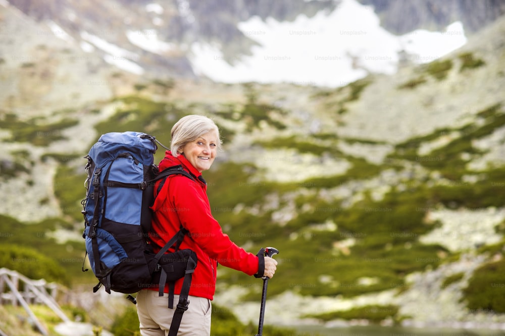Senior tourist woman hiking at the beautiful mountains