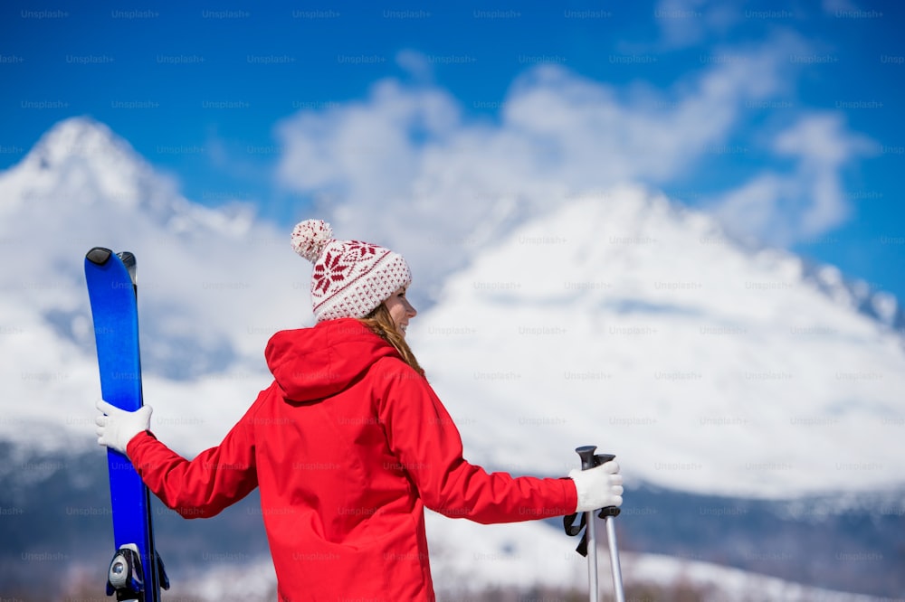 Mujer joven esquiando al aire libre en las montañas soleadas del invierno