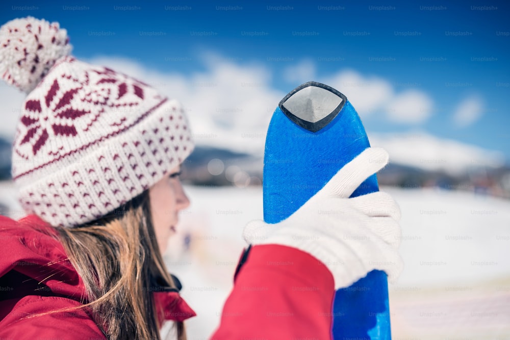 Junge Frau beim Skifahren draußen in sonnigen Winterbergen