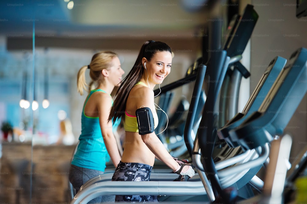 Two young beautiful women working out in gym