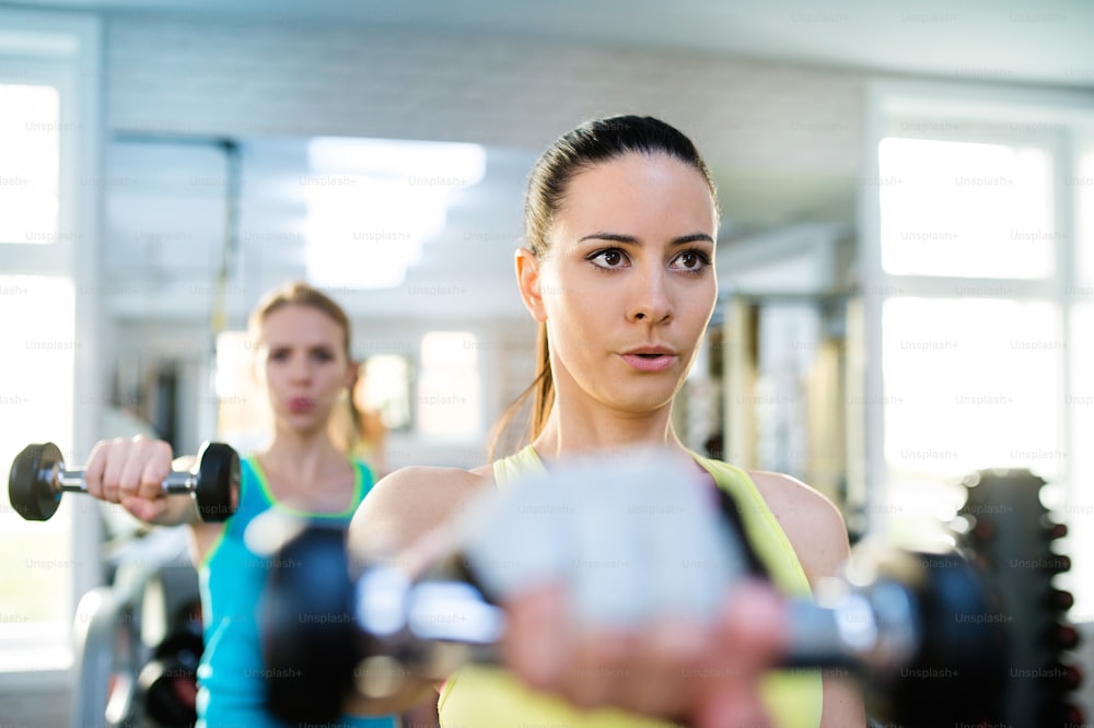 체육관에서 운동하는 두 명의 젊은 아름다운 여성