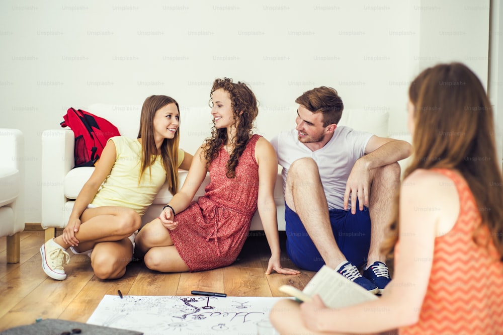 Group of young students studying together and preparing for exams in home interior