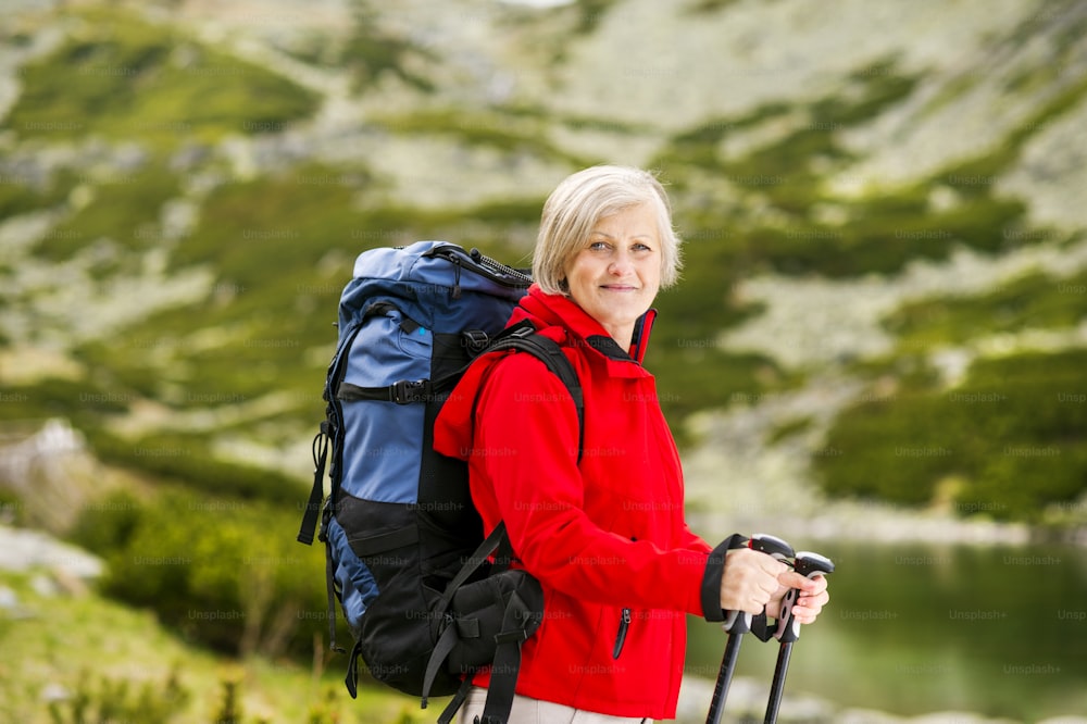 Senior tourist woman hiking at the beautiful mountains