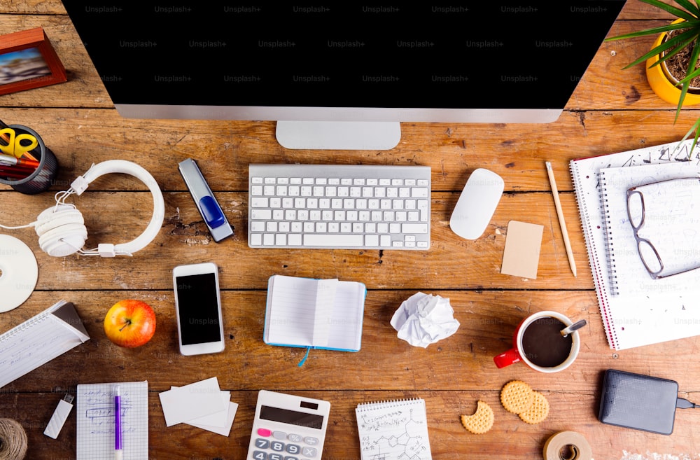 Desk with various gadgets and office supplies. Computer, smart phone and other devices and stationery around the workplace. Flat lay.