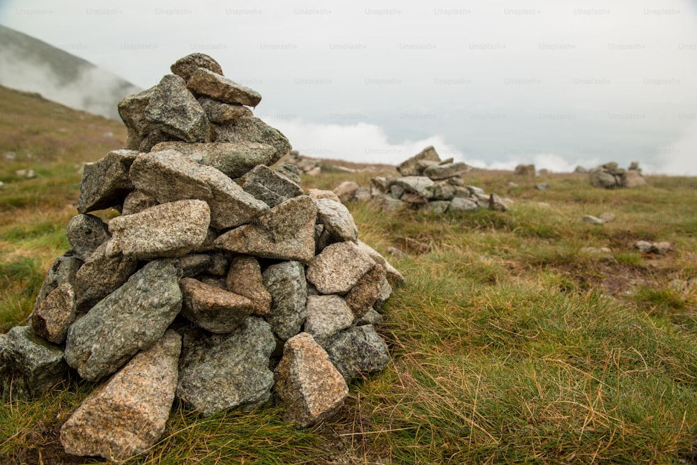 Stacks of rocks stones with cloudy mountains after rain, rainy misty day, High Tatras Slovakia.  Beautiful mountain landscape.