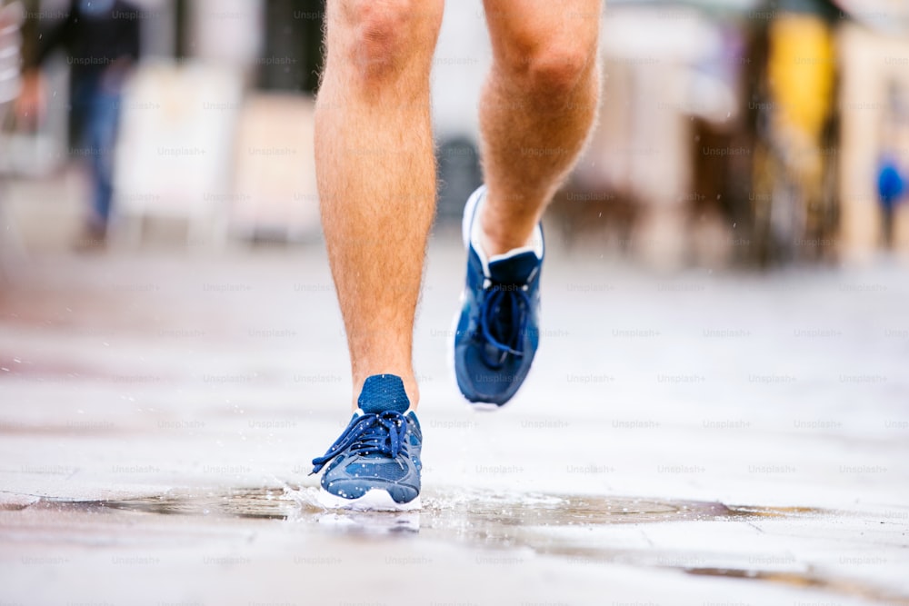 Close up of young hipster runner in town with water bottle, drinking