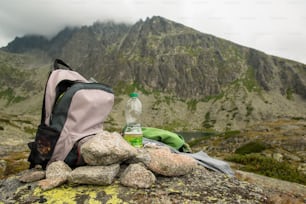 Piedras, mochila y botella de agua. Montañas nubladas y nubladas después de la lluvia, día lluvioso y brumoso, Altos Tatras Eslovaquia.  Hermoso paisaje de montaña.
