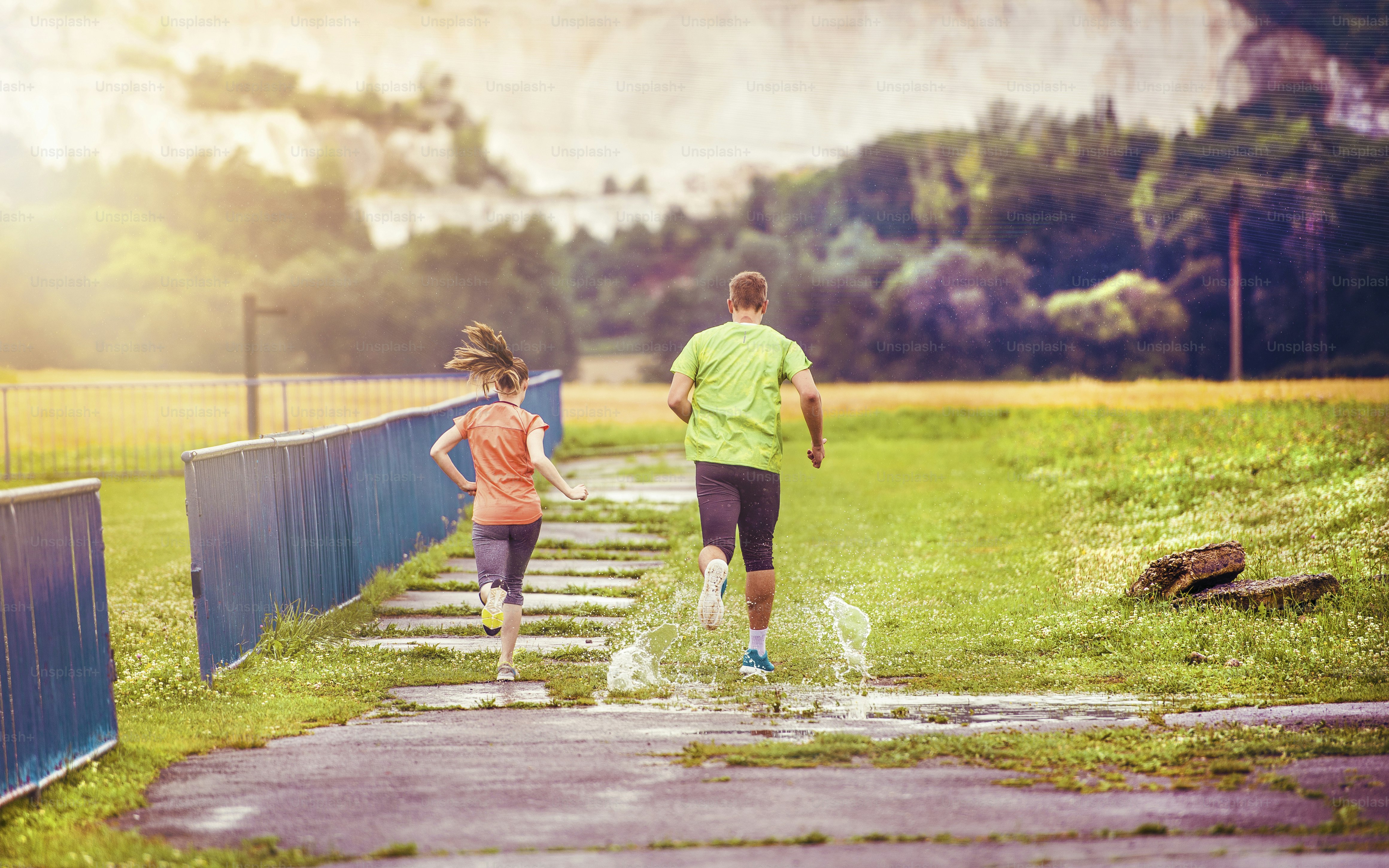 Young couple jogging on asphalt in rainy weather photo – Exercising ...
