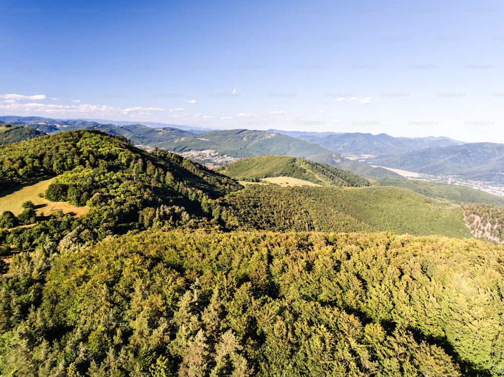 Aerial view of forest, grassland and village with houses during summer day. Slovakia, Nova Bana.