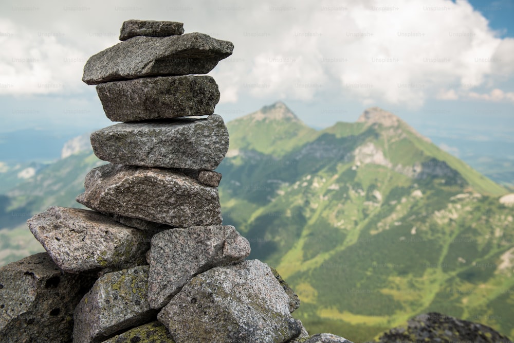 Stack of rocks stones with cloudy mountains after rain, rainy misty day, High Tatras, Slovakia.  Beautiful mountain landscape.