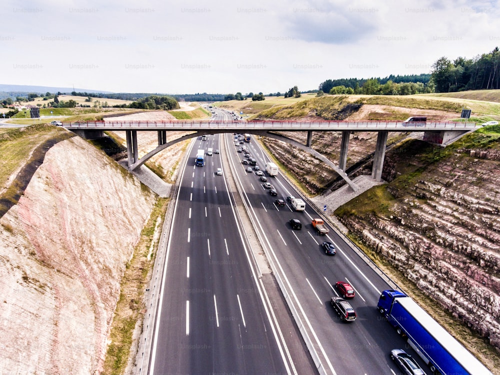 Aerial view of highway full of cars and trucks, traffic jam in the middle of green forest, Netherlands