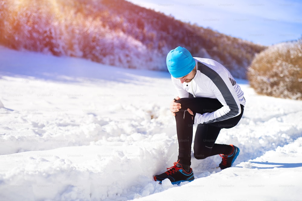 Infortunio di un giovane sportivo che fa jogging all'aperto nel soleggiato parco invernale