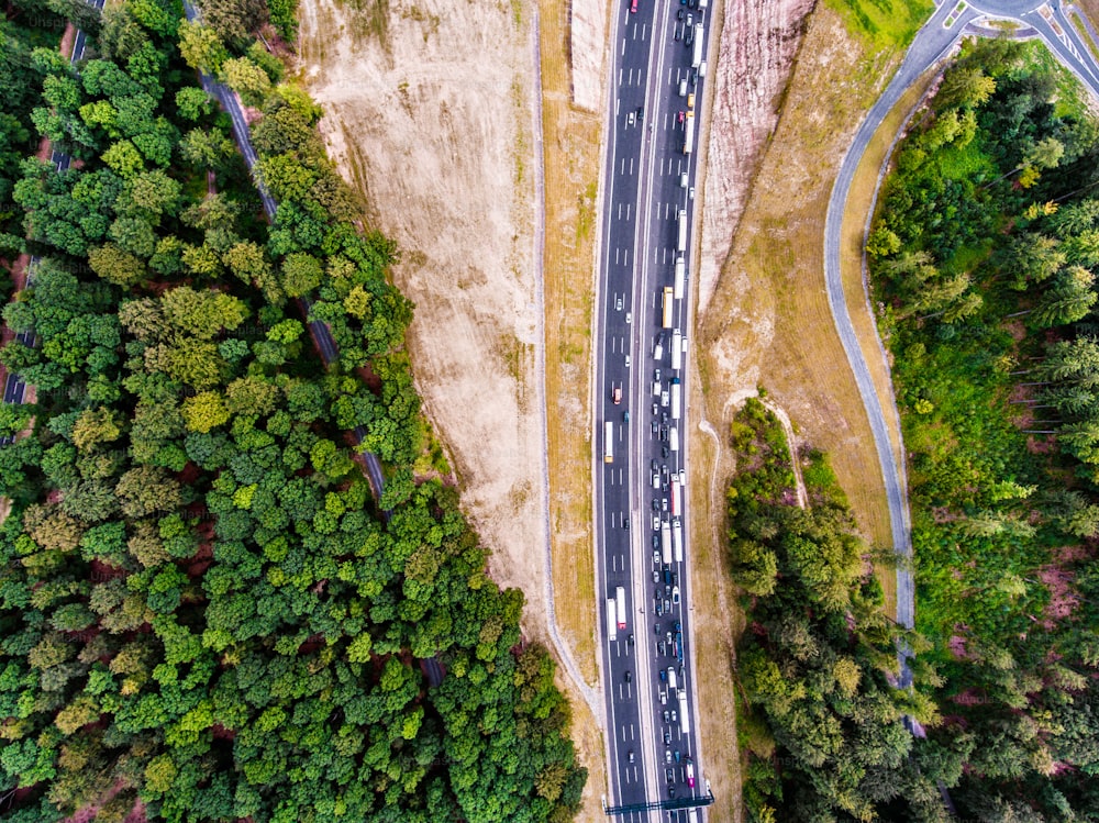 Vista aérea da rodovia cheia de carros e caminhões, engarrafamento no meio da floresta verde, Holanda