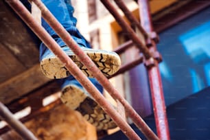 Close up of legs and soles of unrecognizable man standing on scaffold