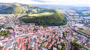 Luftaufnahme der slowakischen Stadt Banska Bystrica, umgeben von grünen Hügeln.