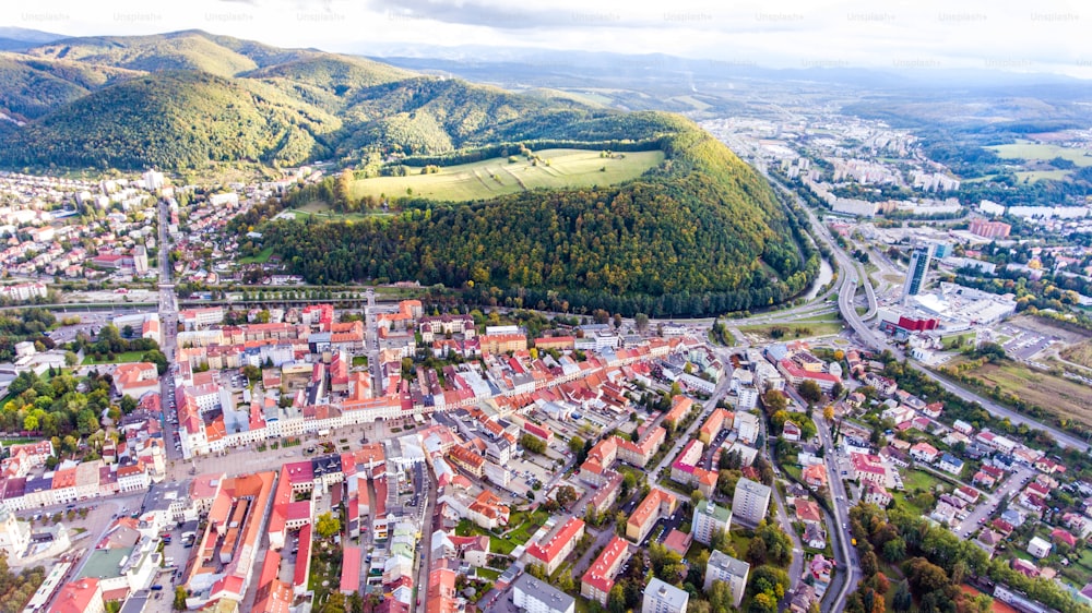 Vista aérea da cidade eslovaca Banska Bystrica cercada por colinas verdes.