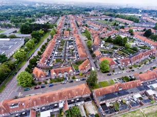 Aerial view of family houses with backyards in residential area of Dutch town