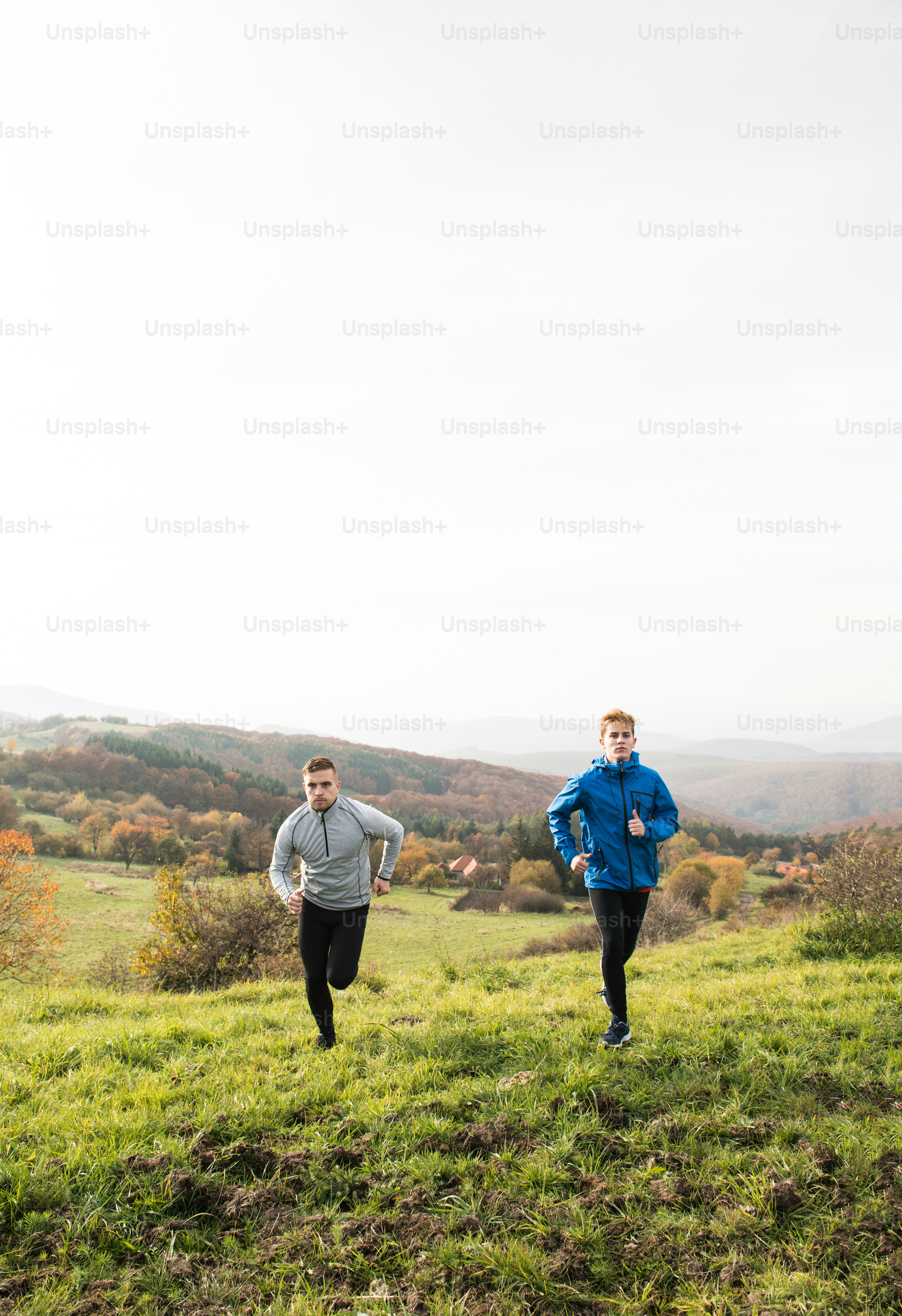 Two young handsome hipster runners in sports jackets in sunny autumn