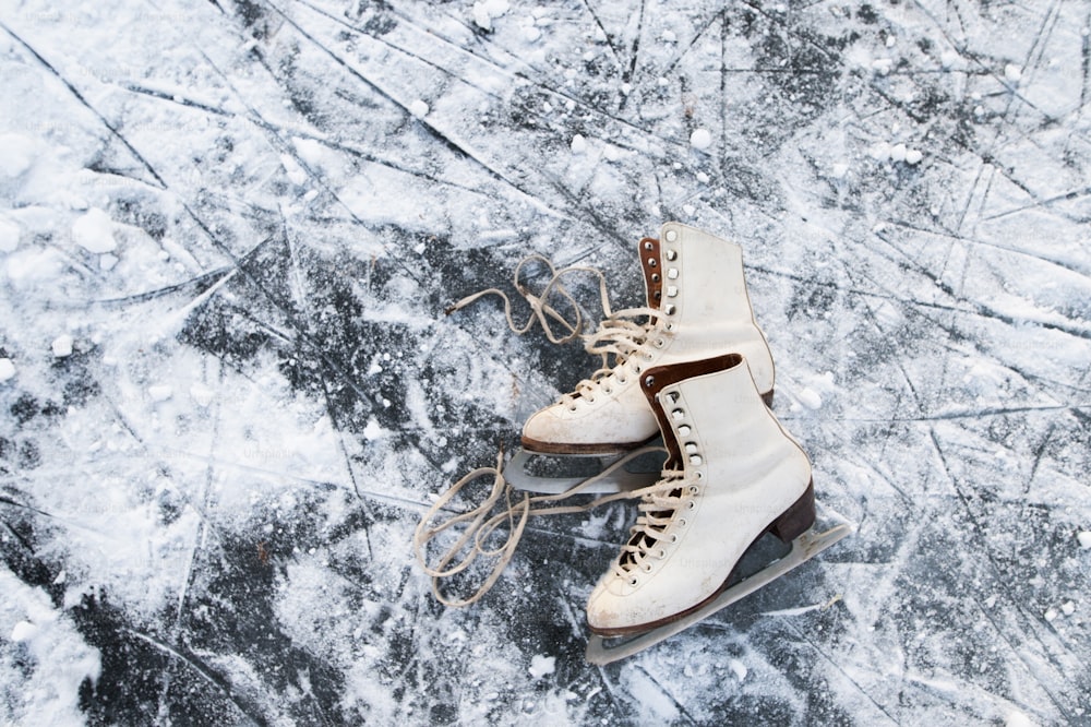 De vieilles patins à glace couchés sur la glace. Gros plan.