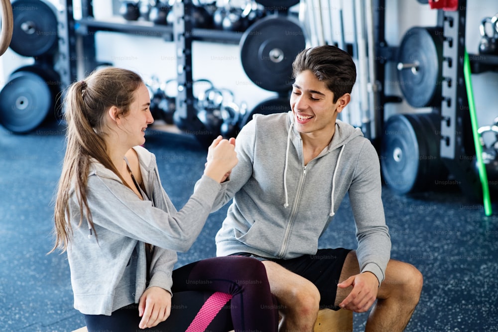 Schönes junges fittes Paar im modernen Fitnessstudio mit Faustpumpe.
