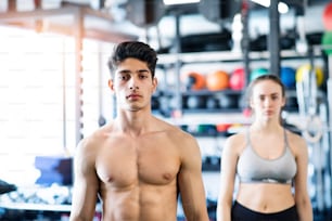 Beautiful young fit couple prepared for exercising in modern gym gym.