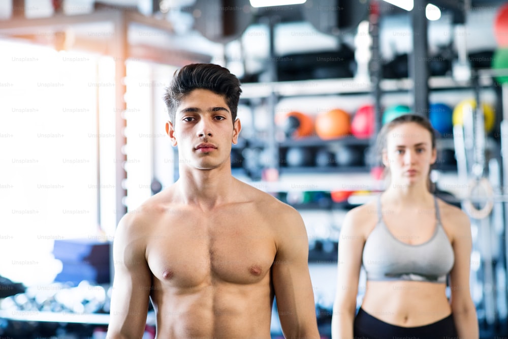Beautiful young fit couple prepared for exercising in modern gym gym.