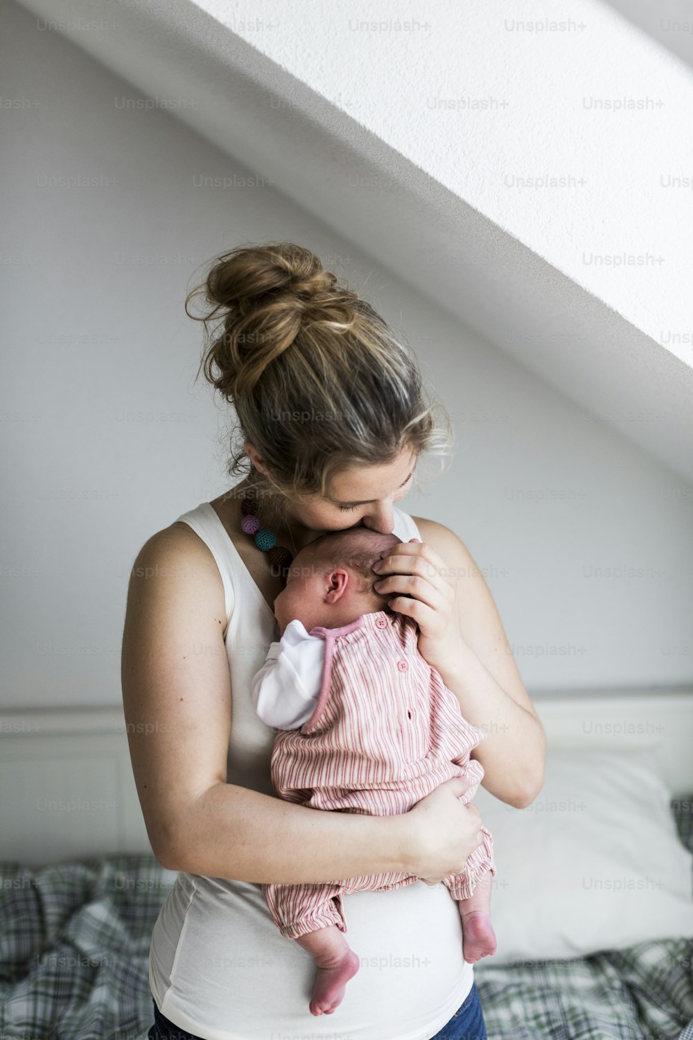 Bela jovem mãe em casa segurando sua menina recém-nascida fofa.