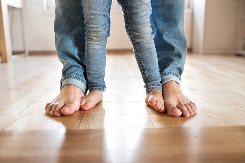 美しい若い家族。父と娘の裸足の接写。